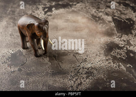 Figurine d'un éléphant en bois sur une base en béton Banque D'Images