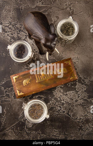 Différents types de thé dans des bocaux en verre, boîte en bois avec plateau et la figurine d'un éléphant en bois Banque D'Images
