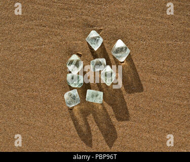 Fluorine octaèdre naturel vert cristaux sur la plage au lever du soleil. Banque D'Images