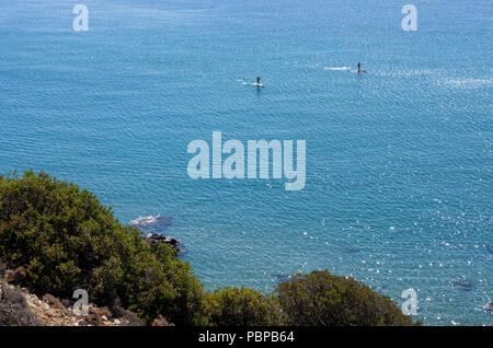 Belle vue de l'île de Rhodes dans la Méditerranée avec deux touristes non identifiés dans la distance consiste en stand-up surf Banque D'Images