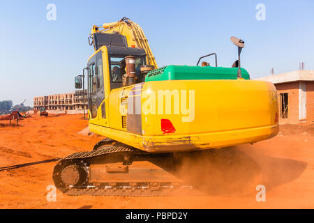 Appartements de construction de l'emplacement de nouveau bâtiment en cours avec l'industrie des machines de terrassement pelle. Banque D'Images