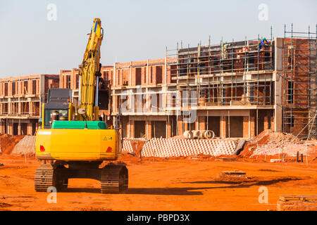 Appartements de construction de l'emplacement de nouveau bâtiment en cours avec la machine excavatrice terrassement. Banque D'Images