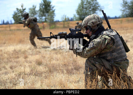 Le s.. Taylor Anderson, chef d'équipe, Alpha Co., 3e bataillon du 161e Régiment d'infanterie, couvre-feu pour le Sgt. Jeremy Tan lors d'un exercice tactique de l'équipe lane le 20 juillet, 2018 at Joint Base Lewis-McChord. 3e bataillon effectue actuellement une formation annuelle de trois semaines. (US National Guard photo par Joseph Siemandel) Banque D'Images