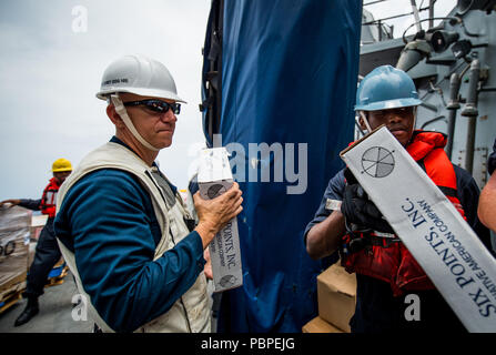 180720-N-LI768-1256 de l'OCÉAN PACIFIQUE (Juillet 20, 2018) - Commande Master Chief Michael Noullet passe une boîte de nourriture à bord du destroyer lance-missiles USS Dewey (DDG 105) connecté au cours d'une reconstitution. Dewey est en cours aux États-Unis de la flotte de 3ème zone d'opérations. (U.S. Photo par marine Spécialiste de la communication de masse 2e classe Devin M. Langer/libérés) Banque D'Images