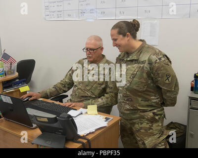 Le sergent de l'armée américaine. Le major Samuel Farley, le sous-officier responsable de la logistique pour le château de Resolute, 2018 et le Major Emily Lynds, l'agent du personnel en charge de RC18, tous deux assignés à 218e Brigade d'amélioration de Manœuvre, en Caroline du Sud, la Garde nationale de la Défense discutent du système de déplacement des recettes pour les opérations quotidiennes à Boleslawiec, Pologne, le 20 juillet 2018. Farley a célébré ses 40 ans de carrière dans l'Armée anniversaire pendant le déploiement de la Garde nationale en Pologne à l'appui de la résolution de l'Atlantique. (U.S. La Garde nationale de l'armée photo par le Sgt. 1re classe Kimberly D. Calkins) Banque D'Images