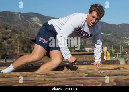 Un joueur de football avec Saint Margaret's Episcopal High School exécute un parcours lors d'un événement de relations communautaires avec 1er Régiment de Marines, 1 Division de marines, au Marine Corps Base Camp Pendleton, en Californie, le 20 juillet 2018. L'événement a donné 1er Régiment de Marines Marines l'occasion de maintenir et de solidifier les relationship-s la communauté. (U.S. Marine Corps photo par Lance Cpl. Maritza Vela) Banque D'Images
