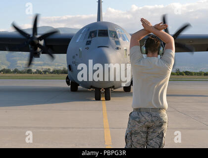 Un aviateur de l'US Air Force avec le 86e Escadron de maintenance des aéronefs marshalls un C-130J Super Hercules à sa place de stationnement dans la région de Plovdiv, Bulgarie, le 22 juillet 2018. Au cours de l'été de Thrace, 37e Escadron de transport aérien pilotes ont effectué plus de 120 heures au cours de 48 sorties pour atteindre les objectifs et établissent des partenariats avec des partenaires bulgares. (U.S. Le sergent-major de la Force aérienne. Jimmie D. Pike) Banque D'Images