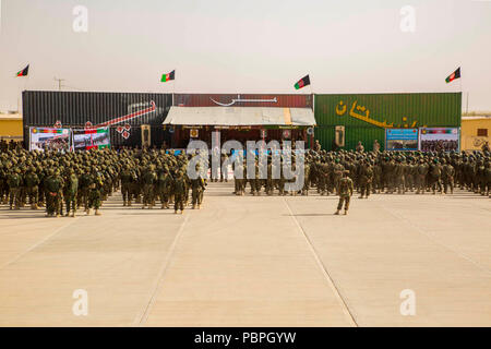 La province d'Helmand, en Afghanistan (Juillet 14, 2018) - Soldats de l'Armée nationale afghane (ANA) 215e Corps et policiers avec la 505ème Zone Police nationale afghane au garde à vous pendant 2e Kandak, 2e cycle de préparation opérationnelle de la Brigade (ORC) Cérémonie de remise de diplômes au Camp Shorabak. L'obtention du diplôme est l'aboutissement de deux mois de l'ORC, qui a permis aux soldats de prendre congé, de résoudre des problèmes administratifs, adopter les leçons tirées, et former pour leur prochaine affectation sur les lignes de front. Les soldats nouvellement diplômés utiliseront leurs connaissances et compétences pour raffinée persistent dans la bataille contre l'ennemi Banque D'Images