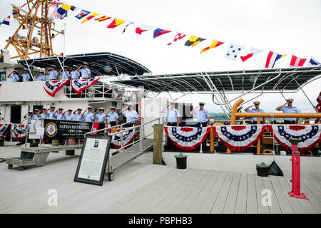 L'équipage de la garde-côte de Nathan mans Bruckenthal les rails et rend un salut de la main au cours de la cérémonie de mise en service du navire à Alexandria, en Virginie, le 25 juillet 2018. La Sentinelle a été la 28e Bruckenthal-class coupe Réponse rapide à mettre en service. (U.S. Photo de la Garde côtière canadienne par le maître de Kyle Niemi) Banque D'Images