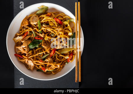 Sauté au wok de nouilles aux oeufs avec du poulet frit et épices thaï, traditionnel et une cuisine asiatique épicée nourriture Banque D'Images