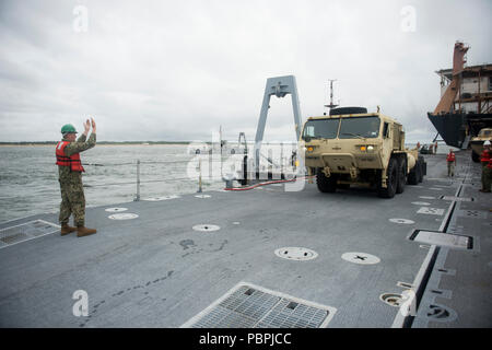 VIRGINIA BEACH, en Virginie, un membre de l'Roll on/Roll Off Installation de décharge (RRDF) guides de l'équipe de l'armée américaine une mobilité élargi lourds Oshkosh (Tuck tactique HEMTT) à l'attente de l'amélioration du système d'allège la Marine (INLS) au cours de la Causeway Ferry Soleil Trident exercice 18. Sun 18 Trident est un prépositionnement maritime force (MPF) opération destinée à assurer la formation de personnel de réserve en ce qui concerne le déchargement dans le flux de véhicules militaires et de l'équipement. (U.S. Photo par marine Spécialiste de la communication de masse 2e classe Kenneth Gardner) Banque D'Images