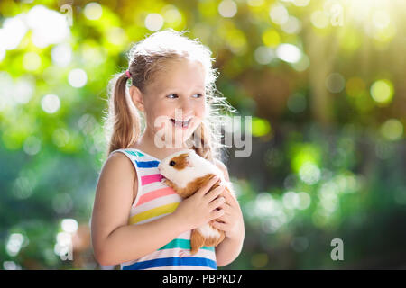 Enfant jouant avec cobaye. Les enfants se nourrissent les animaux. cavia Little girl holding et l'alimentation des animaux domestiques. Les enfants prennent soin des animaux domestiques. Enfant d'âge préscolaire pe Banque D'Images