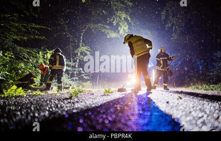 Sehnde, Allemagne. 28 juillet, 2018. 28.07.2018, Basse-Saxe, Sehnde : Les pompiers la réparation de dommages causés par la tempête sur une route de campagne près de Sehnde-Muellingen. Les tempêtes de forte pluie, la foudre et les grains sont en Basse-Saxe. Credit : Julian Stratenschulte/dpa/Alamy Live News Banque D'Images