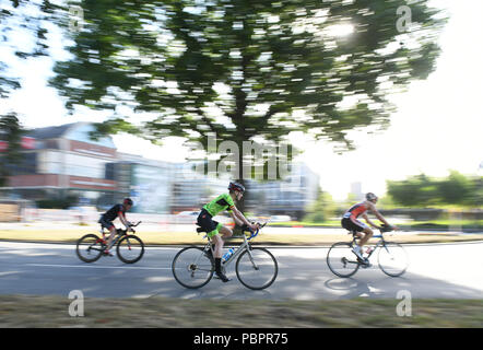 Hambourg, Allemagne. 29 juillet, 2018. Le Triathlon, Ironman World Series : triathlètes circonscription leurs vélos au moyen d'un virage. Crédit : Daniel Reinhardt/dpa/Alamy Live News Banque D'Images