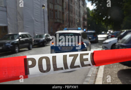 Erfurt, Allemagne. 29 juillet, 2018. 29 Geramy 2018, l'Allemagne, Erfurt : un policier se trouve à un cordon de police dans le centre-ville où il a été capturé après une agression au couteau sur un passant. Le 41-year-old citoyen lituanien, qui avait été recherché pendant des jours de privation de liberté et la tentative de meurtre, avait été identifié sans doute. Il sera présenté dès que possible à un magistrat. Crédit : Martin Wichmann/dpa/Alamy Live News Banque D'Images