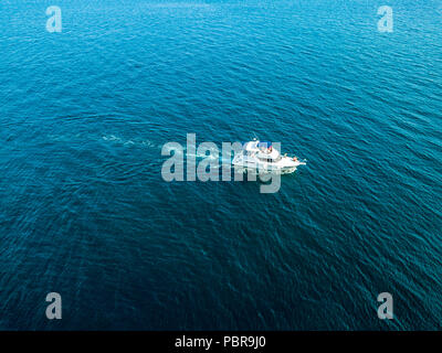 Vue de dessus de l'antenne de vitesse rapide isolées white motor yacht navire sur une surface d'eau de mer Banque D'Images