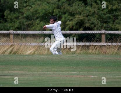 Un joueur lance la balle dans de la frontière dans un match de cricket entre Birch Vale et Thornsett deuxième équipe et Stalybridge St Paul's deuxième équipe. Banque D'Images