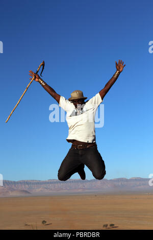 Un guide saute de joie au sommet de la dune Elim dans le Namib-Naukluft National Park, la Namibie. Banque D'Images