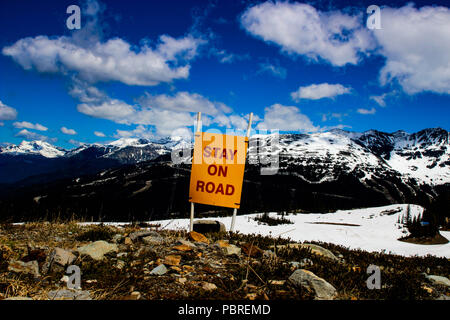 Un panneau d'avertissement de rester sur la route pendant qu'une montagne. Banque D'Images