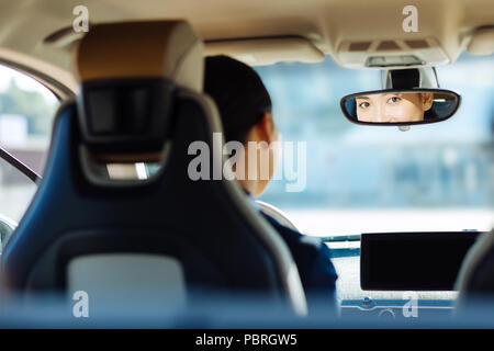 Belle femme agréable à la recherche dans le rétroviseur Banque D'Images