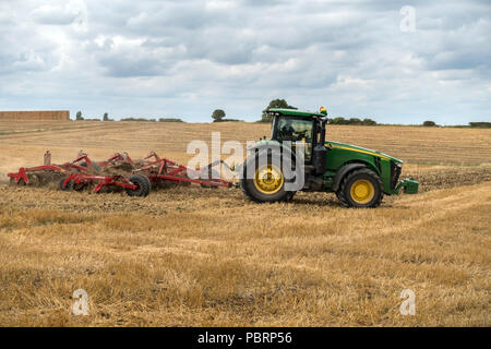 Les machines agricoles Horsch Joker - RT 8 herse à disques (chaume) tiré par John Deere 8370R le tracteur dans le champ de la chaume, Leicestershire, UK Banque D'Images