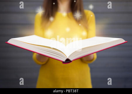 La lumière provenant de livre dans les mains de la femme. Concept de la sagesse, de la religion, de la lecture, de l'imagination, les connaissances Banque D'Images