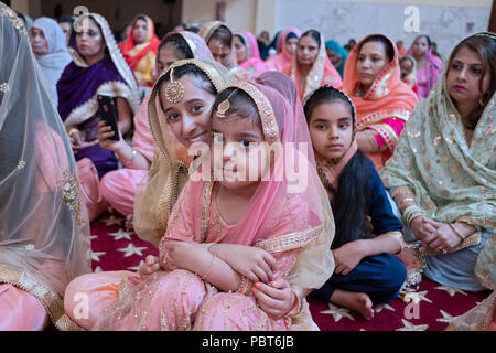 Femmes assis dans le temple, à un mariage sikh à Richmond Hill, Queens, New York. Banque D'Images