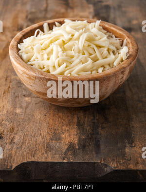 Tas de fromage mozzarella, râpé dans un bol en bois Banque D'Images