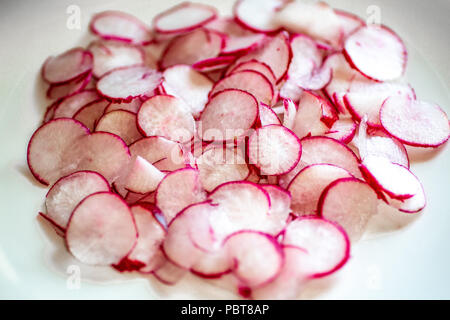 Assiette pleine de radis fraîchement coupées sur le comptoir de la cuisine en attente pour le chef d'utiliser dans une recette. Banque D'Images