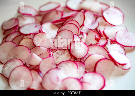 Assiette pleine de radis fraîchement coupées sur le comptoir de la cuisine en attente pour le chef d'utiliser dans une recette. Banque D'Images