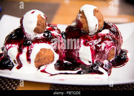 Papanasi - un dessert traditionnel roumain. Le gâteau est fait de trois donuts recouvert de crème sure et de confiture de fruits Banque D'Images