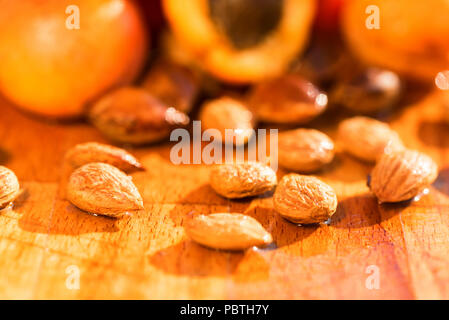 Abricots frais et des pierres sur la surface en bois Banque D'Images