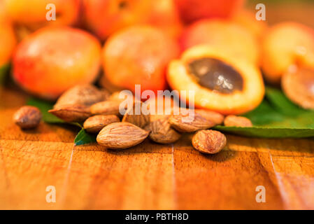 Abricots frais et des pierres sur la surface en bois Banque D'Images