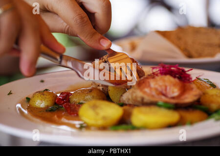 Porc aux pommes de terre au four et de légumes sur une assiette blanche. Banque D'Images