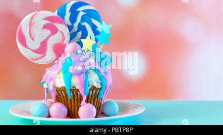 Thème bleu et rose nouveauté colorées décorées cupcake avec des bonbons et des sucettes en forme de grand cœur pour les enfants ou des ados anniversaire, la Saint Valentin ou M Banque D'Images