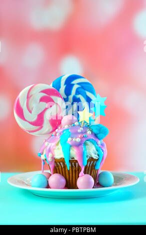 Thème bleu et rose nouveauté colorées décorées cupcake avec des bonbons et des sucettes en forme de grand cœur pour les enfants ou des ados anniversaire, la Saint Valentin ou M Banque D'Images