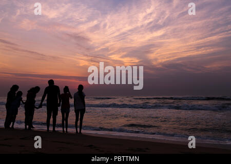 Une famille en attendant le lever du soleil sur Marina beach, Chennai. La beauté de les choses simples de la vie, attendant le lever du soleil avec vos proches Banque D'Images