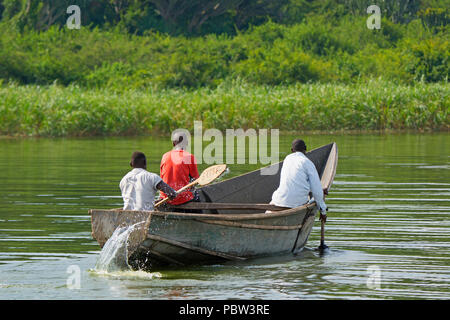 Trois hommes dans un bateau, les pêcheurs de l'Aviron, pagayer le long du canal de Kazinga, Ouganda, Afrique de l'Est Banque D'Images