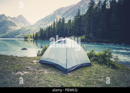 Tourisme et voyages concept. Beau paysage d'été avec des montagnes et de la tente. Tente verte se tient près du lac, dans les montagnes Banque D'Images