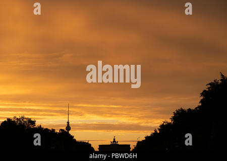 Berlin, Allemagne. 30 juillet, 2018. Le soleil se lève sur la porte de Brandebourg et la tour de télévision. Crédit : Paul Zinken/dpa/Alamy Live News Banque D'Images