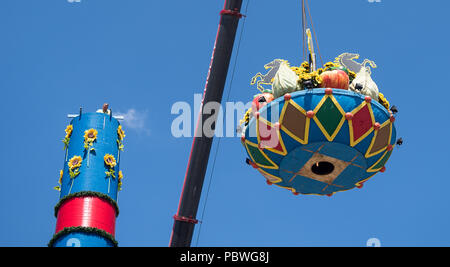 Stuttgart, Allemagne. 30 juillet, 2018. Une grue assemble la colonne 'Fruit' à la Cannstatter Wasen Festival. La colonne est un symbole traditionnel de remerciement pour la récolte et l'élément central de la Cannstatter juste. Cette année, le festival débutera le 28 septembre et se termine le 14 octobre. Crédit : Sébastien Gollnow/dpa/Alamy Live News Banque D'Images