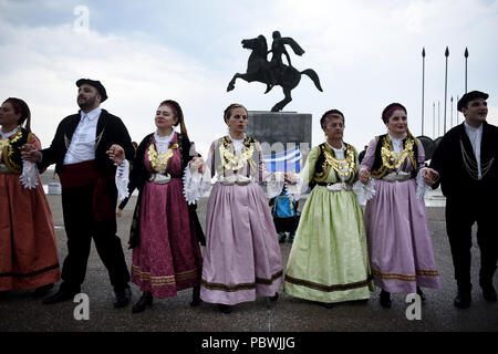 Thessalonique, Grèce. 30 juillet, 2018. Des gens habillés en costumes traditionnels de la danse en face de la statue d'Alexandre le Grand sur le front de mer de Thessalonique. Des centaines de personnes ont dansé au bord de l'eau de la partie nord de Thessalonique, un Grec Macédonien traditionnel danse appelée ''Mmacédonienne Syrto'', afin de protester contre l'Accord sur Prespa débat entre la Grèce et la Macédoine. Credit : Giannis Papanikos/ZUMA/Alamy Fil Live News Banque D'Images