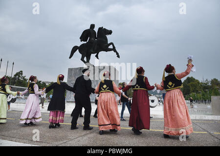 Thessalonique, Grèce. 30 juillet, 2018. Des gens habillés en costumes traditionnels de la danse en face de la statue d'Alexandre le Grand sur le front de mer de Thessalonique. Des centaines de personnes ont dansé au bord de l'eau de la partie nord de Thessalonique, un Grec Macédonien traditionnel danse appelée ''Mmacédonienne Syrto'', afin de protester contre l'Accord sur Prespa débat entre la Grèce et la Macédoine. Credit : Giannis Papanikos/ZUMA/Alamy Fil Live News Banque D'Images