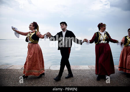 Thessalonique, Grèce. 30 juillet, 2018. Des gens habillés en costumes traditionnels de danse au front de mer de Thessalonique. Des centaines de personnes ont dansé au bord de l'eau de la partie nord de Thessalonique, un Grec Macédonien traditionnel danse appelée ''Mmacédonienne Syrto'', afin de protester contre l'Accord sur Prespa débat entre la Grèce et la Macédoine. Credit : Giannis Papanikos/ZUMA/Alamy Fil Live News Banque D'Images