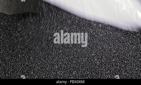 Noir en plastique granulé gris crumb. Fabrication de tuyaux d'eau en plastique usine. Procédé de fabrication de tubes en plastique sur la machine-outil avec l'utilisation de l'eau et la pression de l'air. Banque D'Images