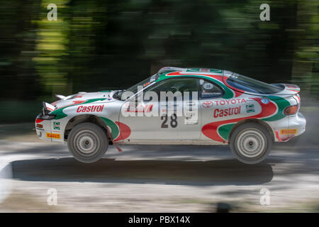 Une Toyota Celica GT-FOUR ST185 voiture rallye bondit dans l'air pendant les courses à travers la forêt rally étapes au Goodwood Festival of Speed 2018 Banque D'Images