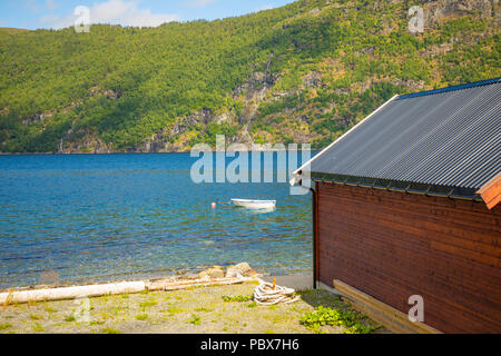 En bois norvégien typique rorbu cabane sur la plage de Sunny fjord journée d'été en Norvège Banque D'Images