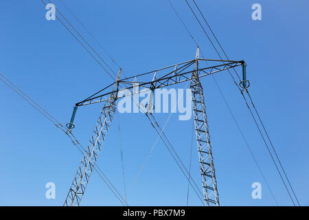 Ligne à haute tension avec un pylône isolés contre un ciel bleu. Banque D'Images