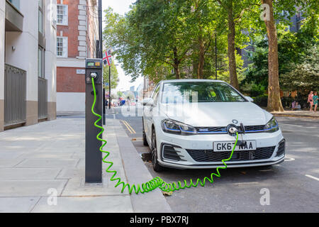 Londres, Angleterre, Royaume-Uni ; 27 juillet 2018 ; White Volkswagen Golf GTE Voiture hybride électrique chargement dans une rue du centre de Londres Banque D'Images