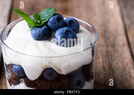 Gâteau au chocolat trifle myrtille en verre sur une table en bois rustique, de délicieux dessert d'été Banque D'Images